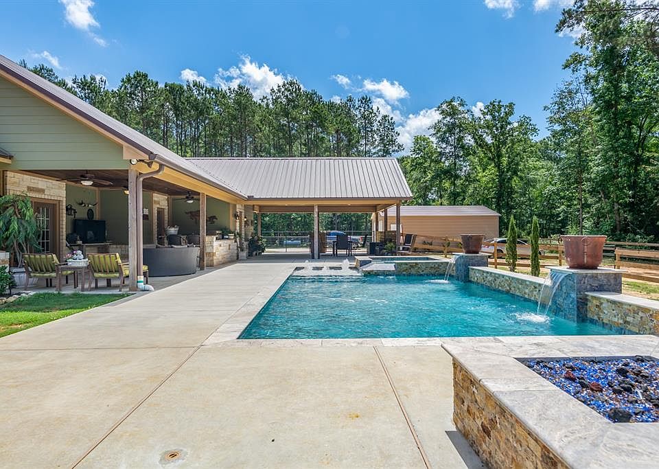 Can you imagine coming home to this? This outdoor living space offers a Custom Pool with Spa spillway, fountains and two sheer waterfalls, glass fire table, outdoor Kitchen, and HUGE dining, lounge and relaxation areas. What more could you want?