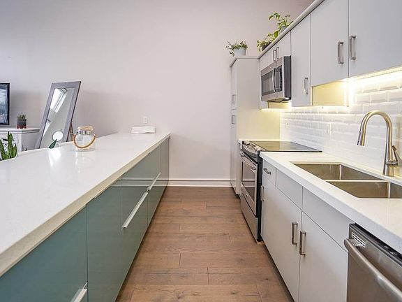 Kitchen walkway with room to cook with your friends. Modern, European cabinets with trendy cabinet pulls. Hidden within the island are multiple "secret" compartments for clean storage (including trash and recycling receptacles).