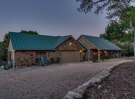 To the left of the garage in a huge workshop wired with 220V outlets. Notice the green set of stairs. Workshop is accessible from garage and a separate exterior door (the green set of stairs in where the exterior door is).