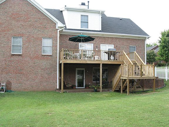 Rear of home with patio and newly-refurbished deck 