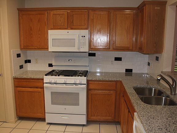 New granite countertops, gas range and oven, sink, and microwave.