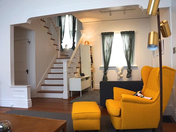 View of living room looking up the stairs. Kitchen is to the left past the door; the door leads to basement.