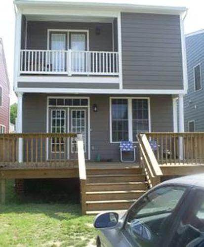 Back of house with deck and parking for two cars