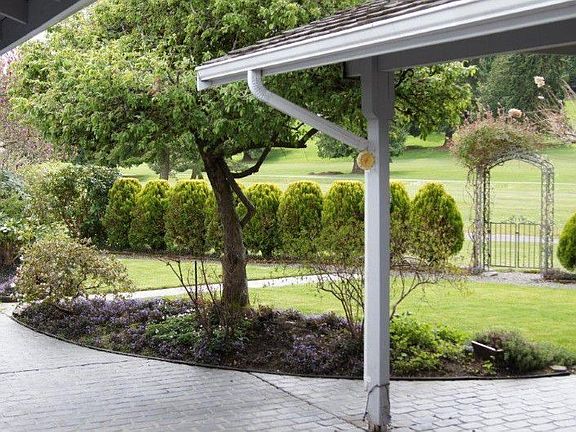 Rear yard with view of golf course. The patio is partially covered and includes built-in cabinets.