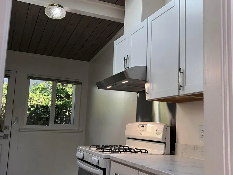 Kitchen's newer cabinets, gas stove, oven and hood.