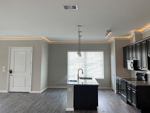 Kitchen has dark wood cabinets and beautiful backsplash.