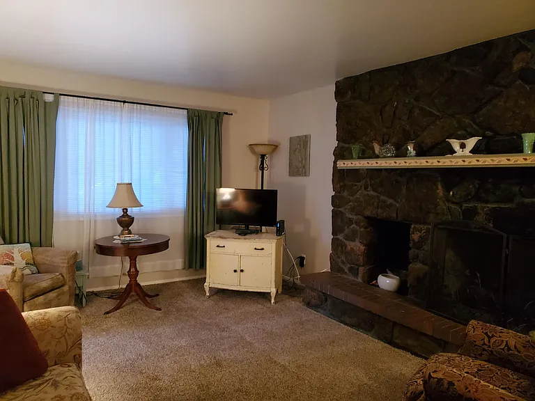 Living room including picture window - staging with furniture. House is unfurnished and no longer has carpet - now has new luxury vinyl flooring.