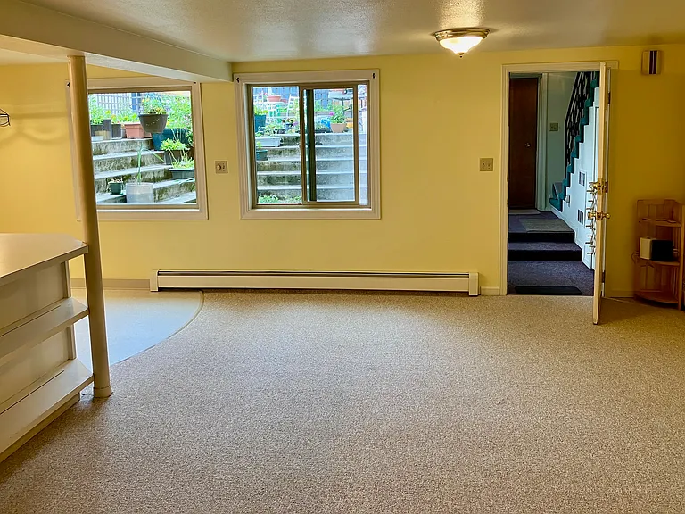 Livingroom, looking out to entryway, patio and stairs up to laundry room.