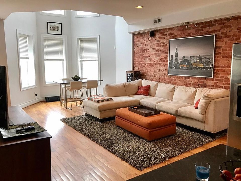Open concept living room with high ceilings, large bay windows, and 20ft ceiling over dining space