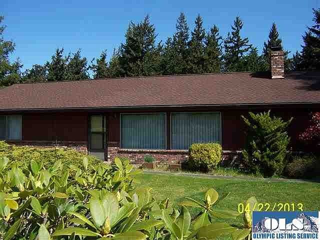 The front of this home is oriented to the south with a full Olympic mountain range view. It is setting at the crest of a gentle hill fronted by a row of rhododendrons.