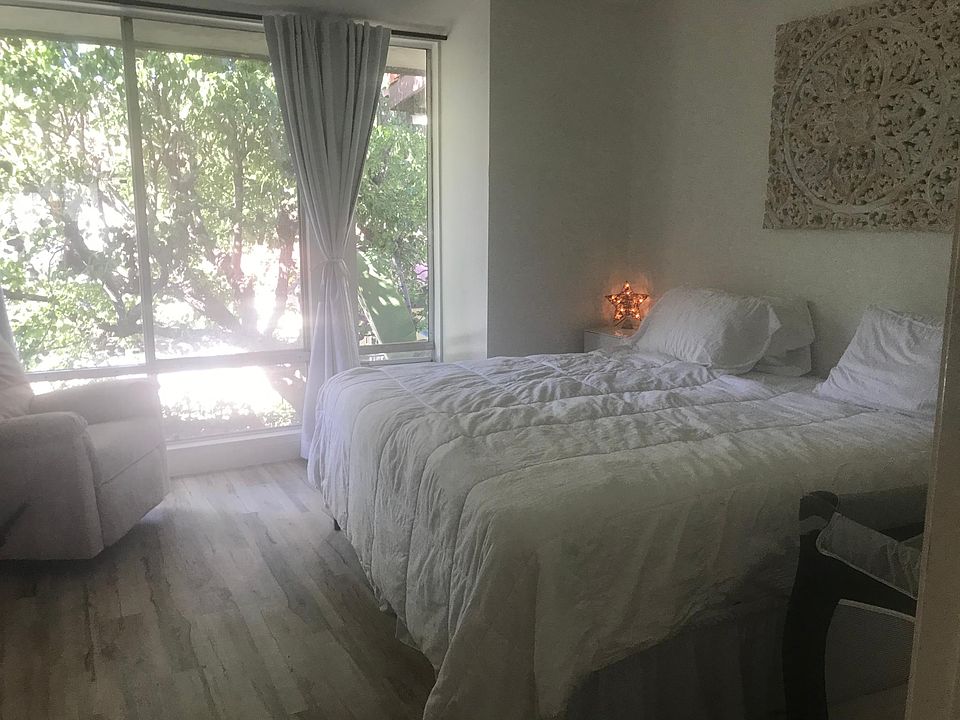 Bedroom overlooking the pool and jacuzzi shaded by a large tree