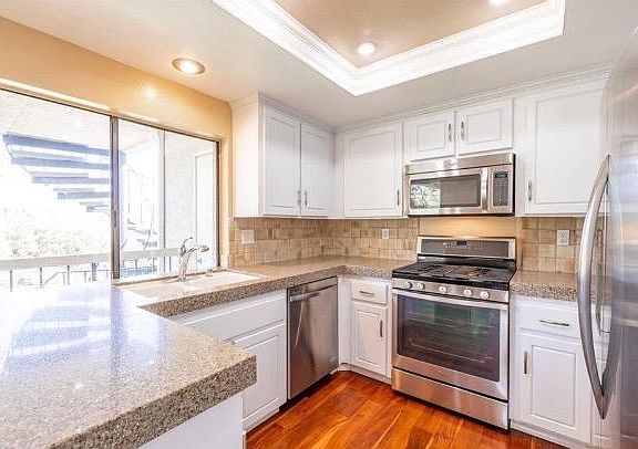 Amazing kitchen with large windows, and stainless steel appliances.
