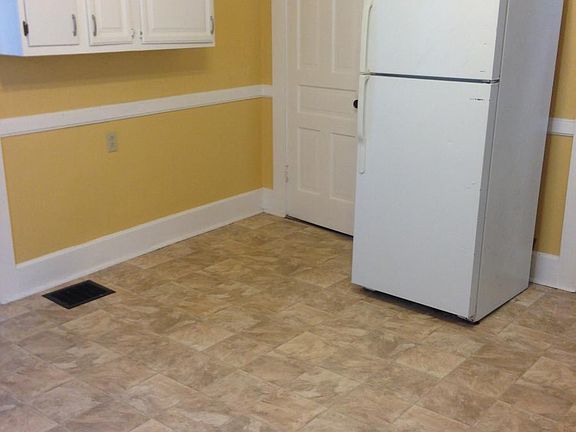 Door on left of Frig is the bathroom.