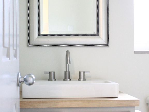 Bathroom with beautiful vanity, sink, faucet and lighting.