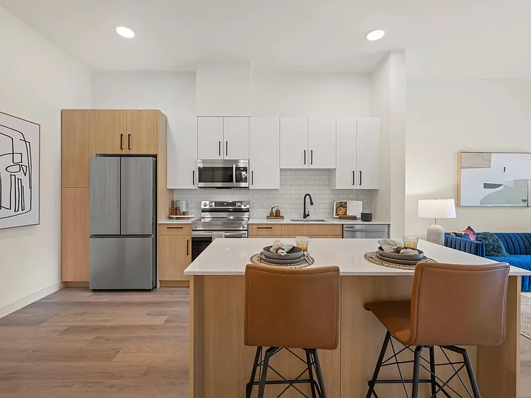 Gourmet kitchens include quartz countertops and modern two-tone cabinetry.