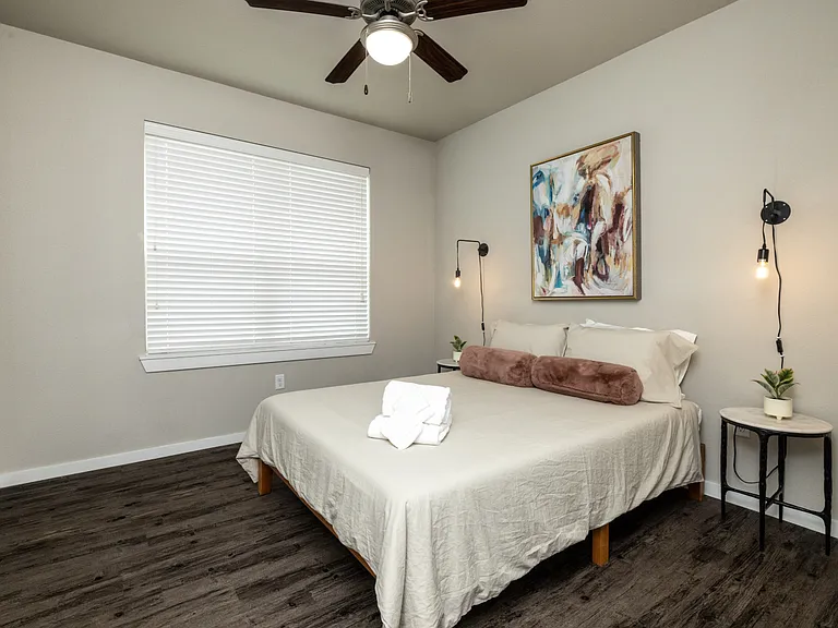 Stylish second bedroom featuring a queen bed and elegant Art Deco pendant lights on each side_designed for comfort with a touch of glamour. This bedroom is located upstairs.