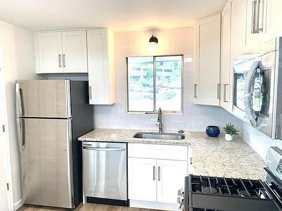 Completely NEW! Sleek modern kitchen is bright & airy with sunny skylight, stainless steel appliances, and open plan layout.