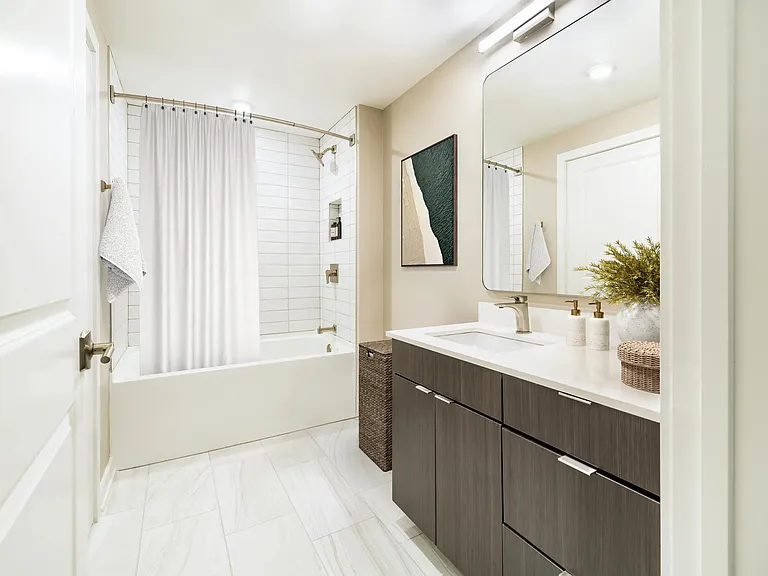 A bright, streamlined bath at Modera Parkside in Atlanta features clean tilework and polished finishes, with easy access to Midtown and nearby green spaces.
