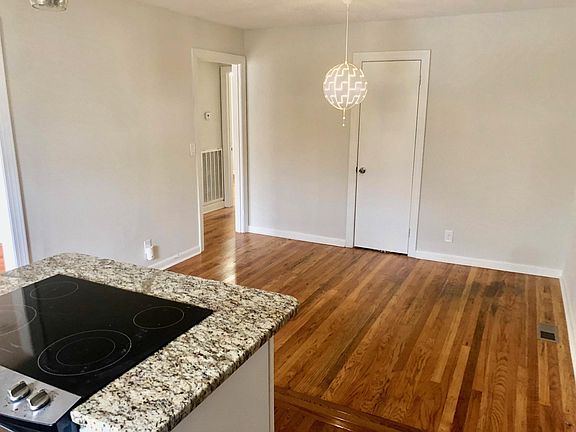 View into dining area from kitchen island with custom stove and Ikea lighting.