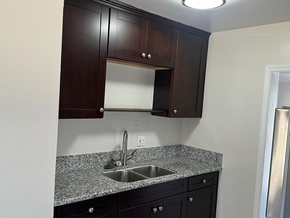 Kitchen sink with granite and nice cabinets.