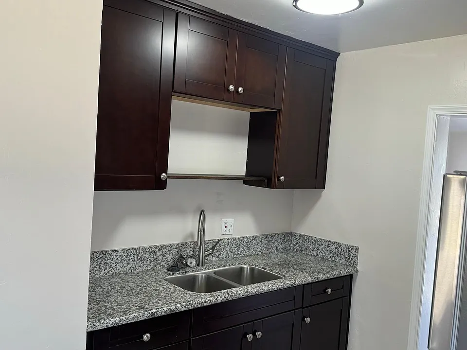 Kitchen sink with granite and nice cabinets.