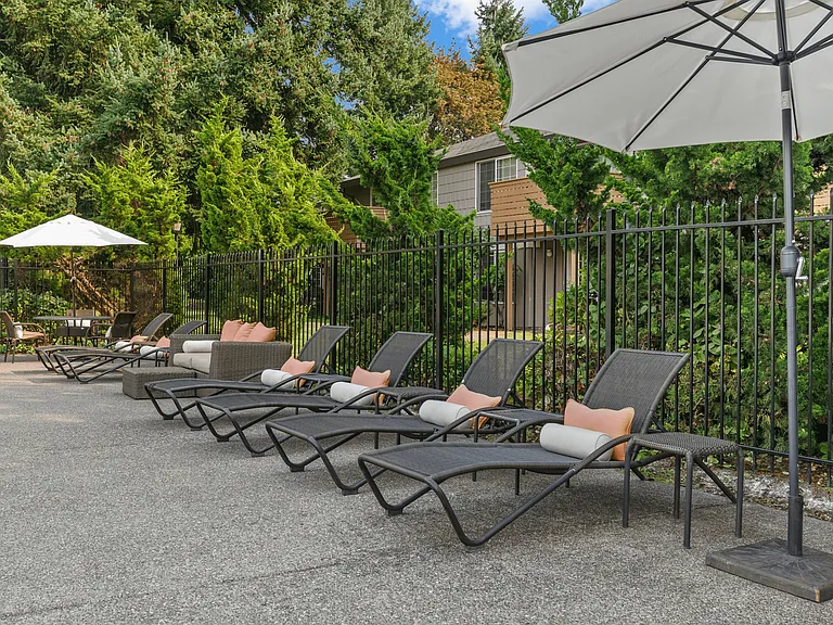 Comfortable poolside seating surrounded by lush landscaping.