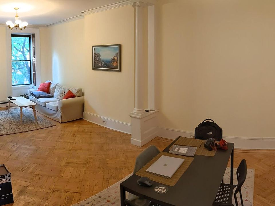 huge living room/dining room facing south, historic details, newly sanded hardwood floors (taken as a wide-angle shot)