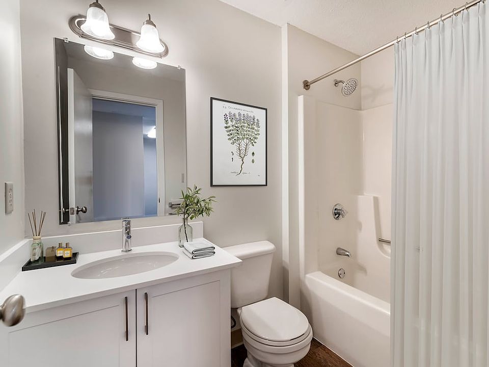 Renovated Package I bath with white laminate countertops, white cabinetry, and hard surface flooring