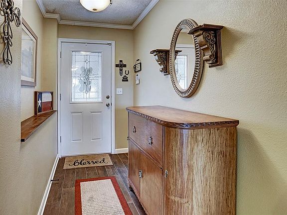 Entry way to the home, wood look tile, and custom wood ledge. This area also features crown molding.