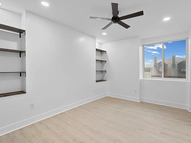 Primary bedroom with ceiling fan and walk-in closet