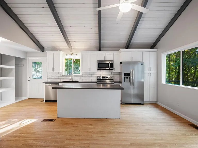 Updated bright & open concept kitchen with quartz counter tops, stainless appliances & vaulted ceilings.