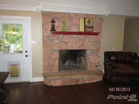 The stone fireplace adds a touch of warmth to the den