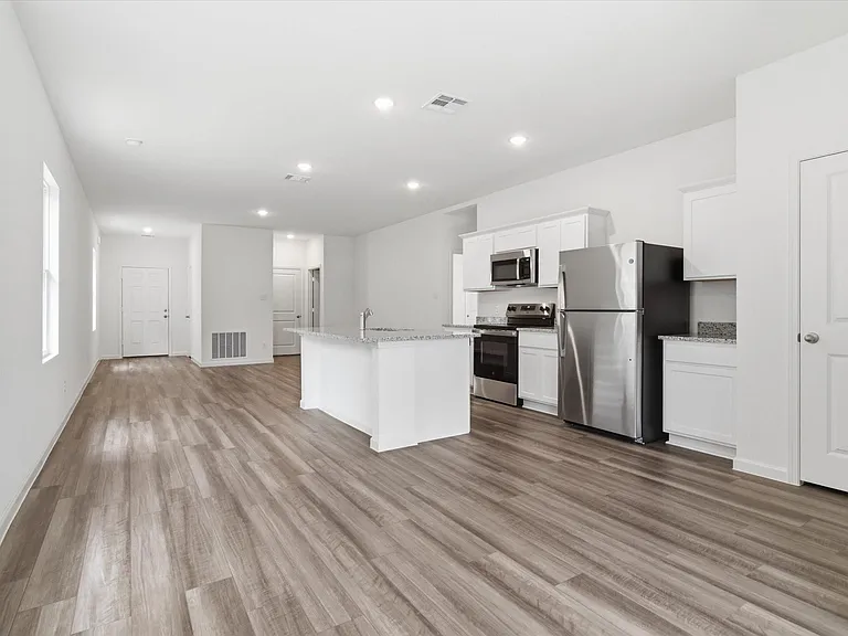 Open-concept living area featuring wood-finish flooring, white walls, and recessed lighting
