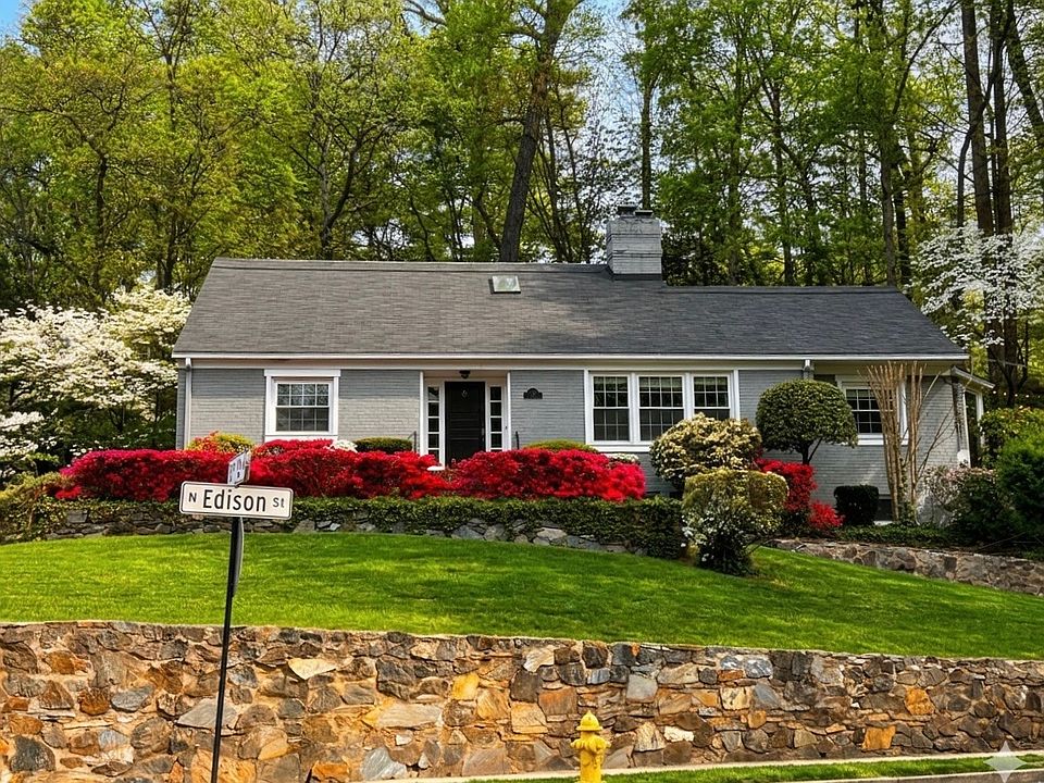 Front of house with blooming hedges on nearly 1/2 acre corner lot.