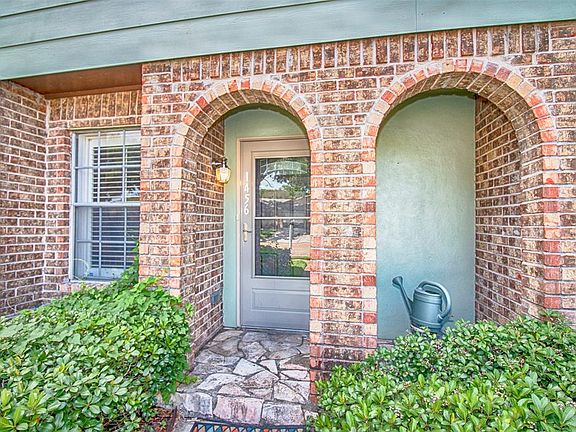 Wonderful arched entryway and lush landscaping that gives this townhome home great curb appeal.