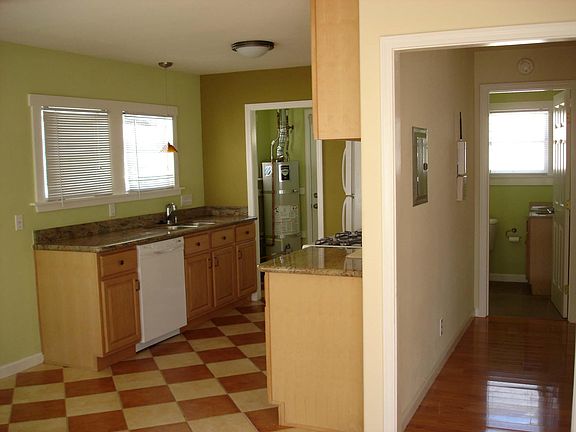 Kitchen and hallway (now painted a light beige). The dishwasher is now stainless steel. Laundry is next to water heater.
