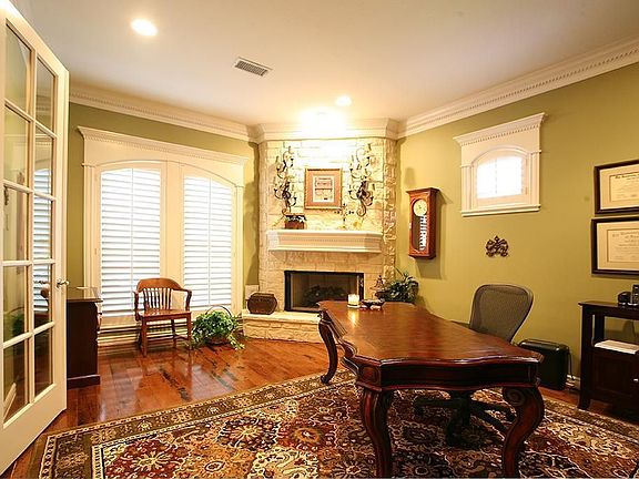 What an awesome study with Stone Fireplace, Hardwoods and custom molding throughout.