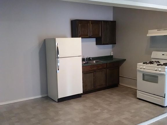 Kitchen includes refrigerator and stove/range with range hood,oak cabinets, ample space for a small kitchen table
