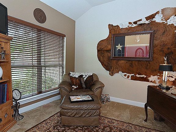 THE STUDY OVERLOOKS THE BEAUTIFULLY LANDSCAPED FRONT YARD AND FEATURES DOUBLE GLASS FRENCH DOORS