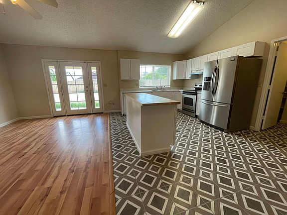 Funky kitchen design with new floors, cabinets, and stainless steel appliances with room to add ad a dining table