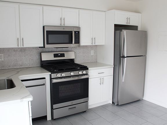 NEW eat in kitchen with stainless appliances, dishwasher, and quartz countertops