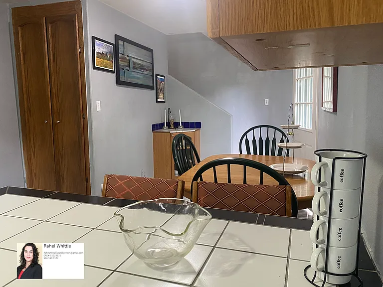 different angle showing downstairs entryway, dining and living area adjacent to breakfast nook
