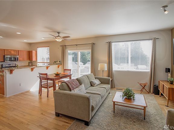 Living room & kitchen with breakfast bar and lots of windows to let the natural light in. 