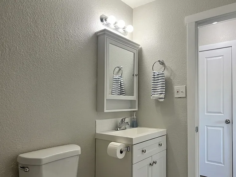Freshly updated main bathroom featuring a brand new modern vanity, stylish hardware, and crisp paint.
