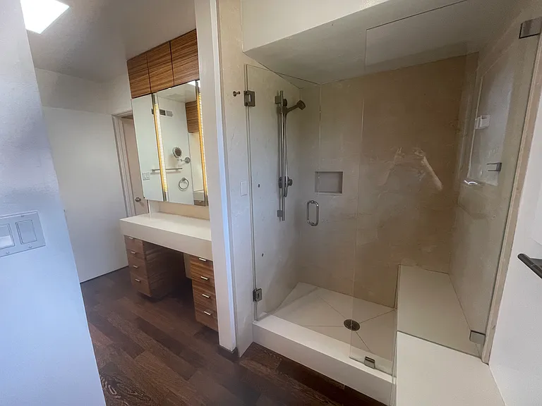 Remodeled primary bathroom with double sinks and seperate stall shows