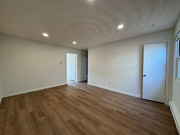 Large living room with recessed lighting and coat closet.