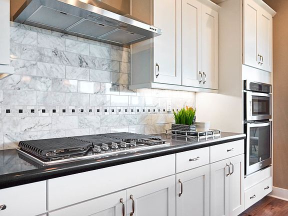 Built-in appliances and upgraded tile backsplash detail in the kitchen.