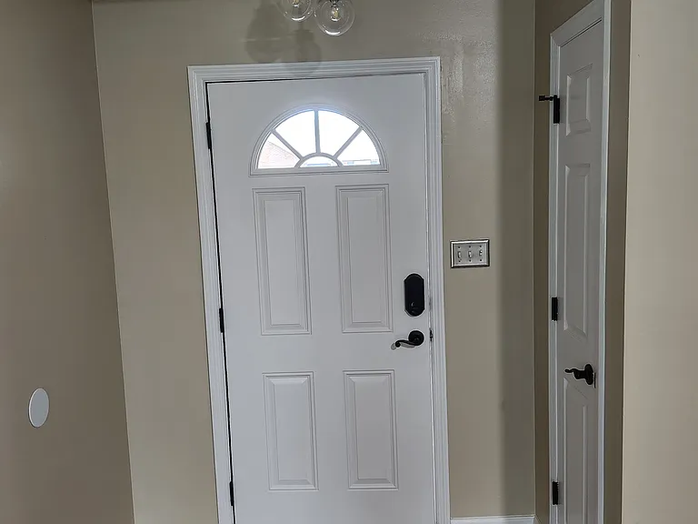 View once you enter the property; freshly painted (white) front door and trim; small coat closet nearby.