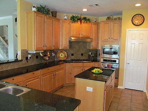 DYNAMIC KITCHEN WITH GRANITE COUNTERS, ISLAND, STAINLESS APPLIANCES, TILE BACK SPLASH, TILE FLOORING,LOTS OF CABINETS,WITH 1/2 BATH AND LAUNDRY ROOM JUST AROUND THE CORNER