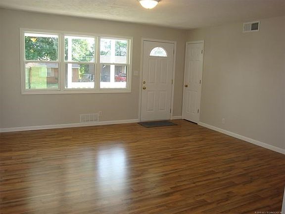 Living room towards from door & entry closet, looking from dining area. New flooring & paint throughout.
